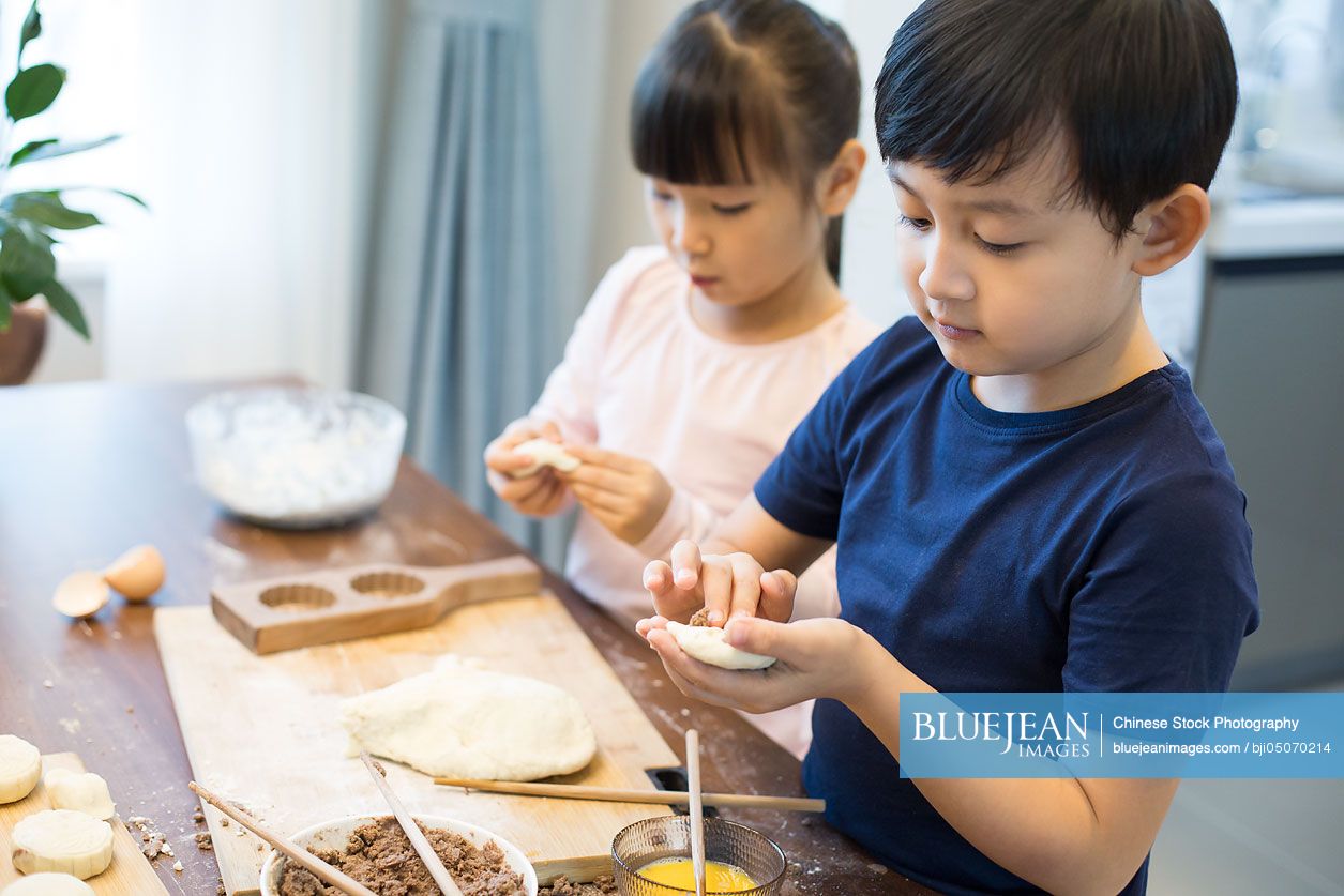Happy Chinese siblings baking together