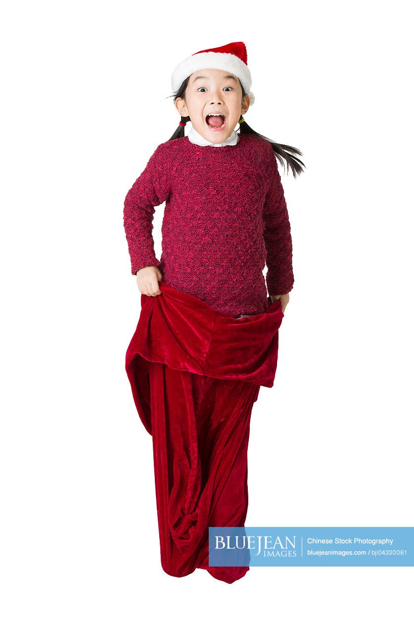 Happy Chinese girl jumping in large Santa bag