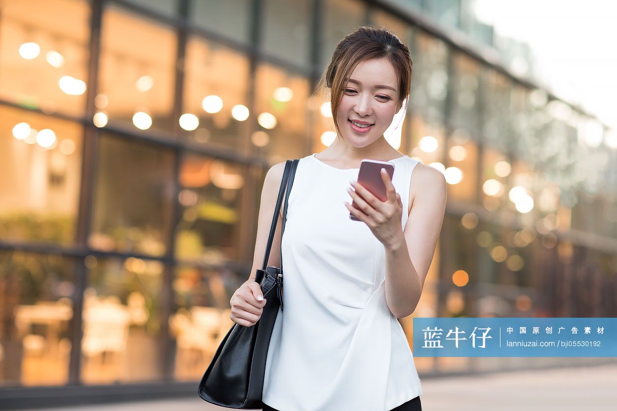 自信的年轻商务女子使用手机