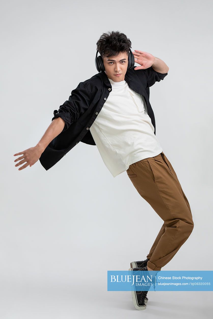 Cool young Chinese man dancing with headphones