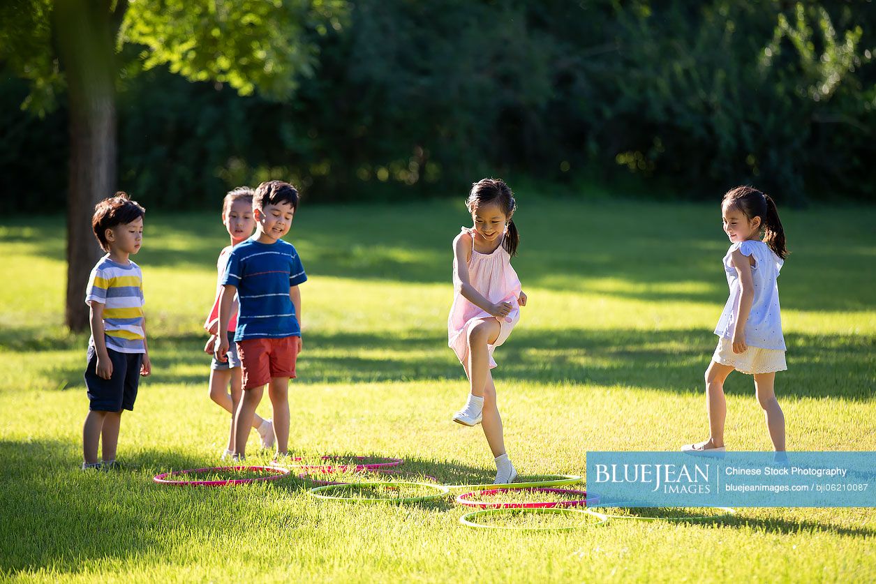 Happy Chinese children playing on meadow