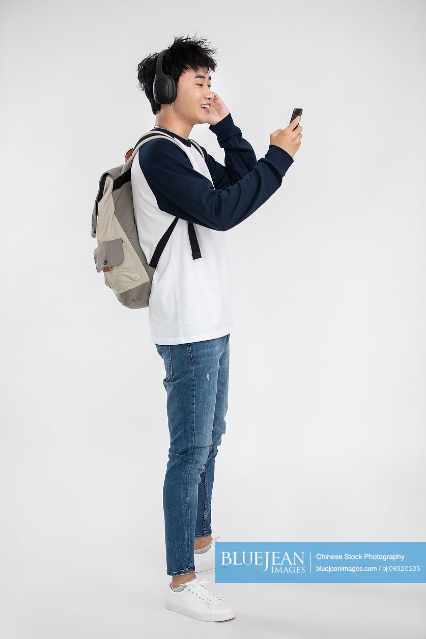 Fashionable young Chinese man listening to music