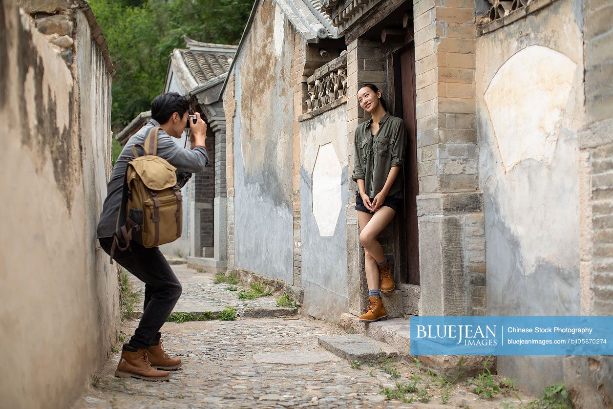 Young Chinese couple taking photos outdoors