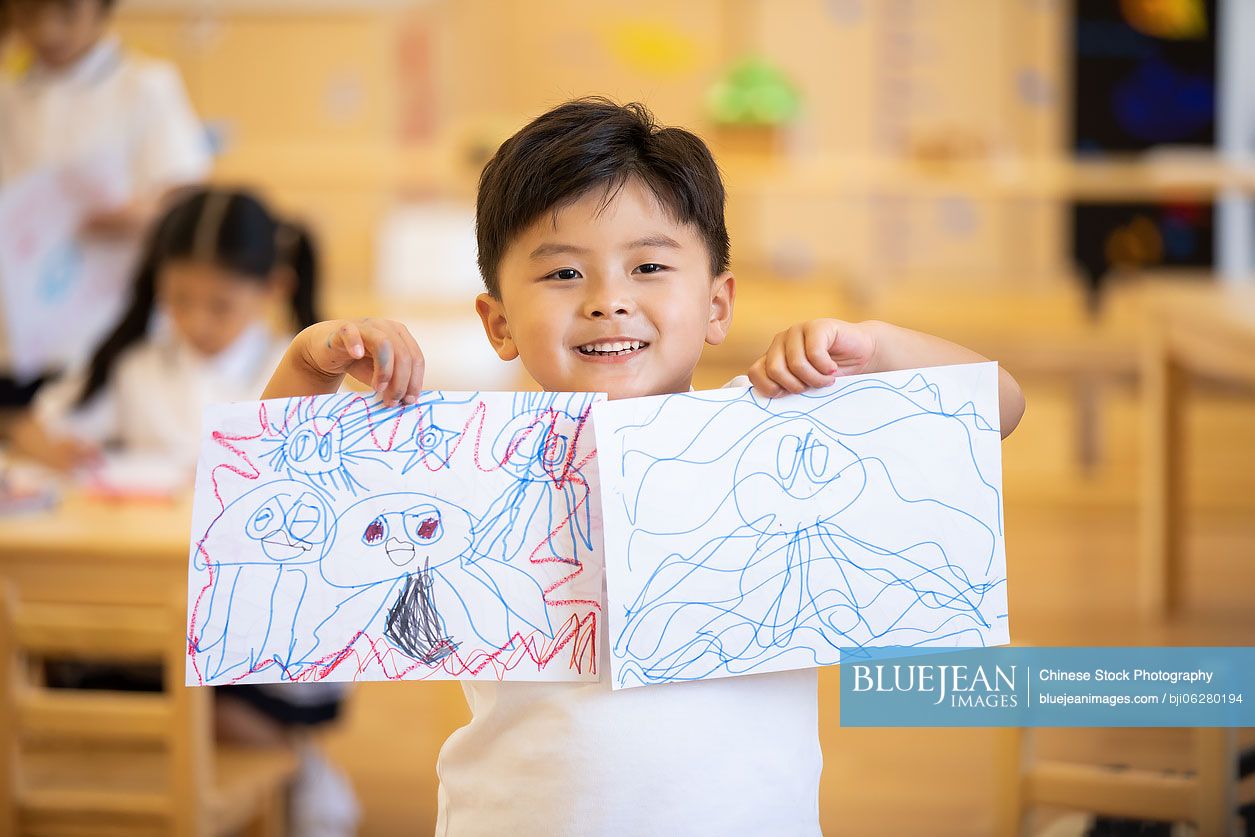 Little Chinese boy showing his painting