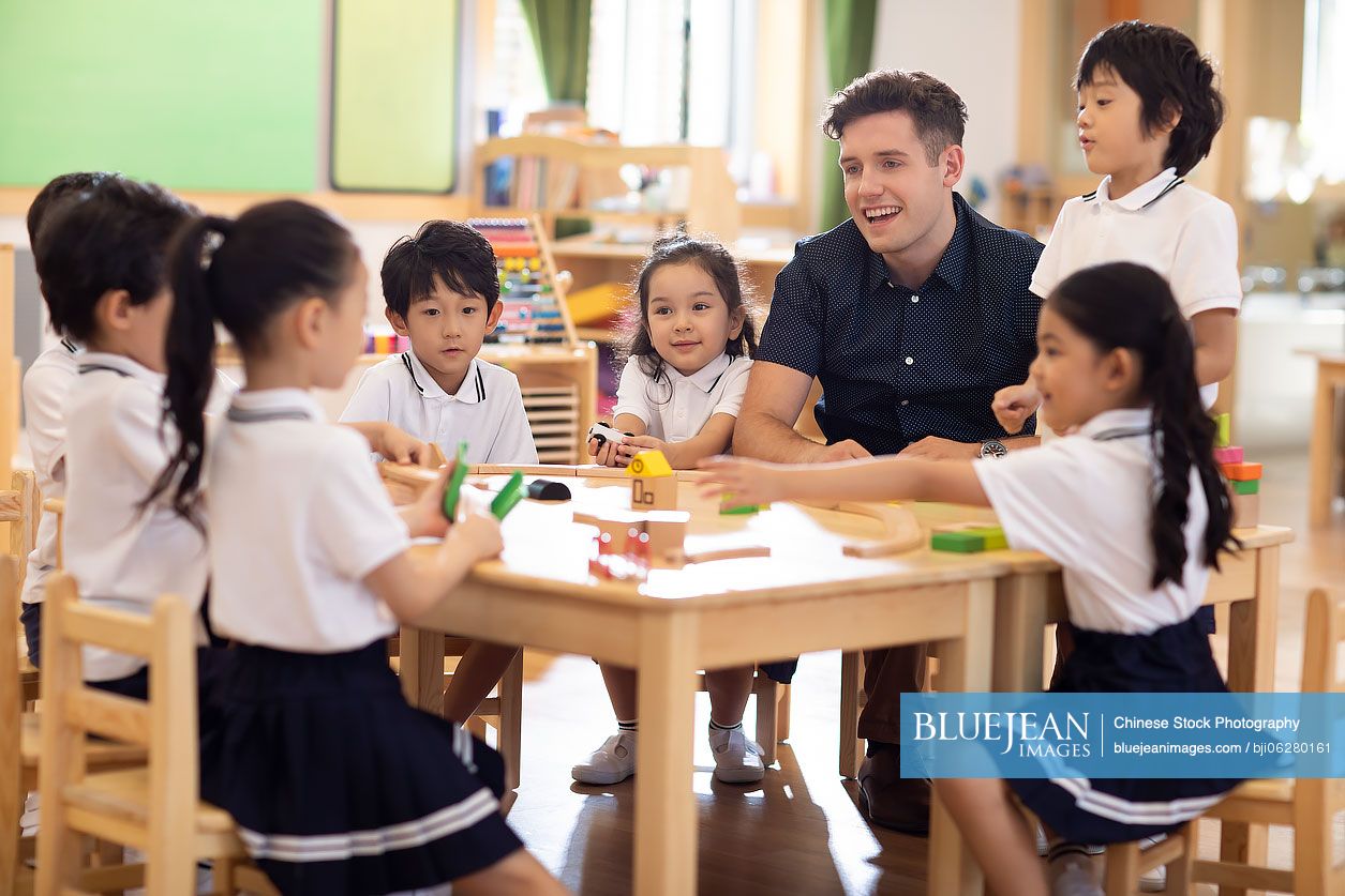 Foreign teacher and children playing in classroom