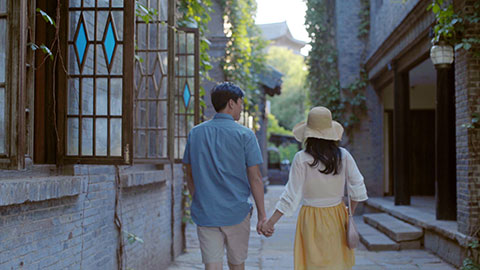 Happy young Chinese couple walking in alley,4K