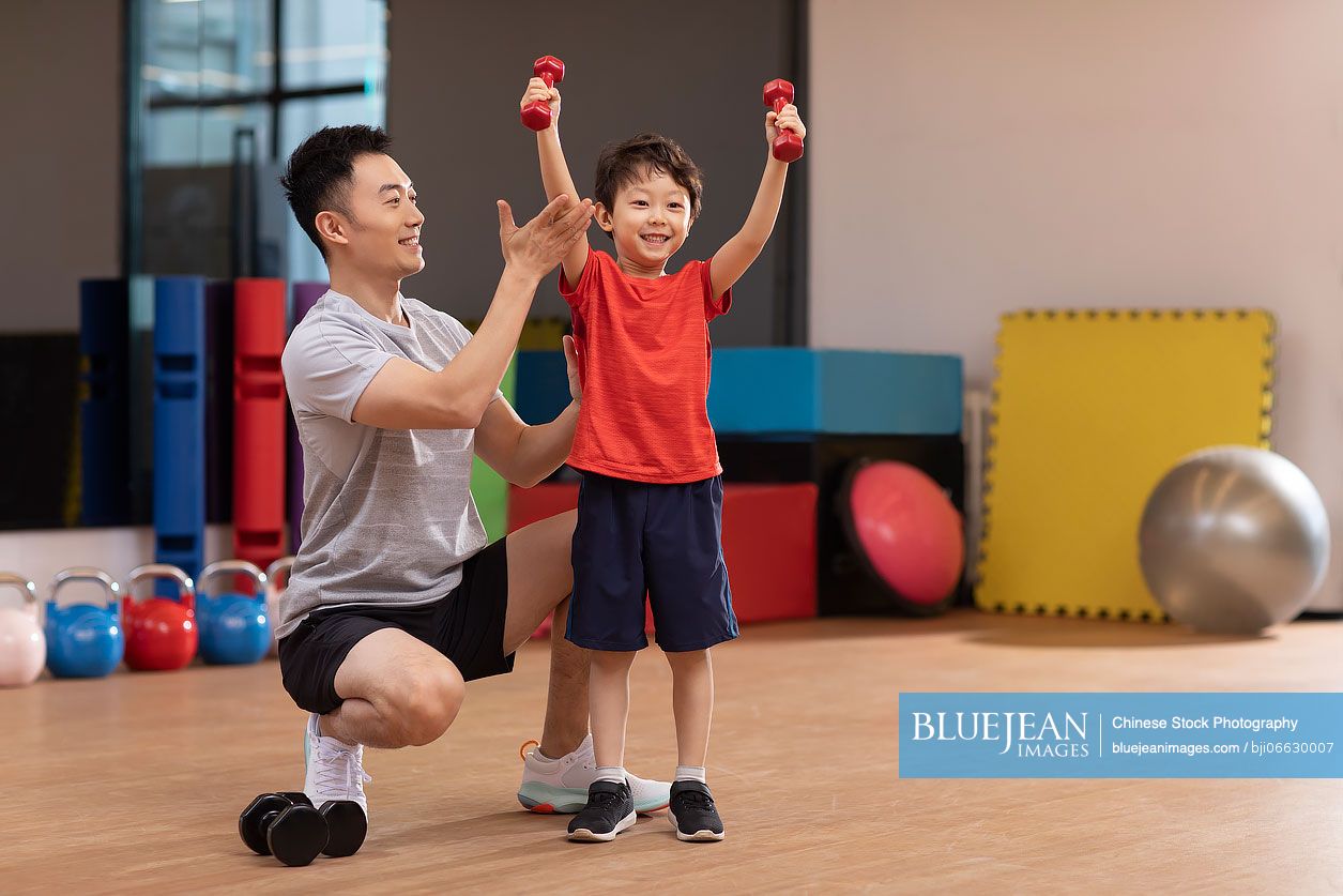 Little Chinese boy having exercise class in gym