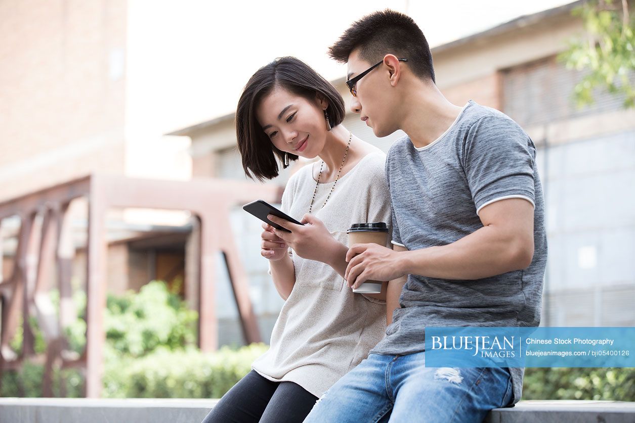Young Chinese couple talking outdoors
