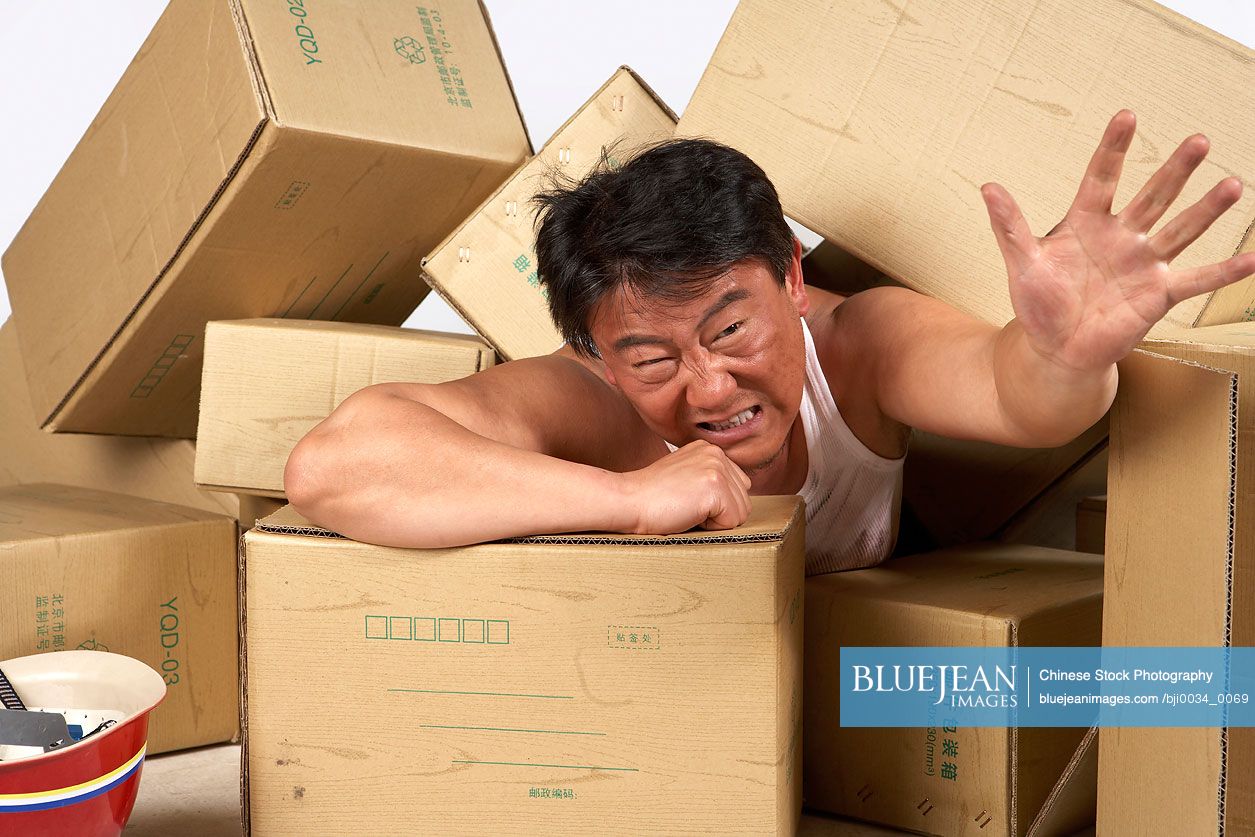 Chinese man trapped underneath boxes