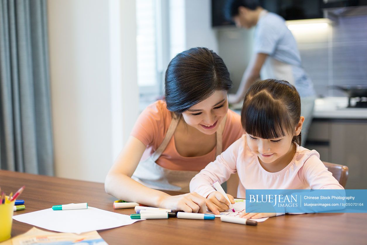 Happy Chinese mother and daughter drawing pictures