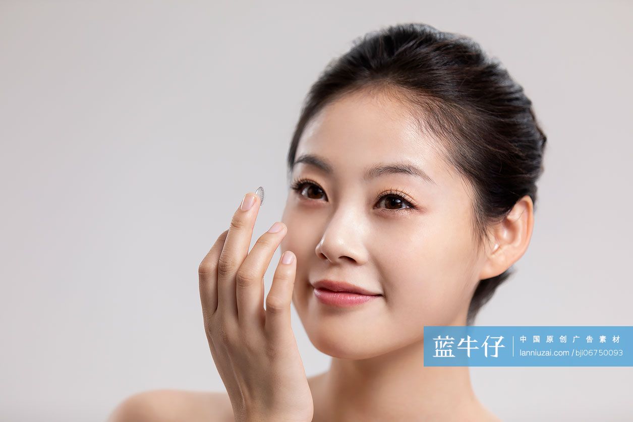 漂亮的年轻女子拿着隐形眼镜 蓝牛仔影像 中国原创广告影像素材