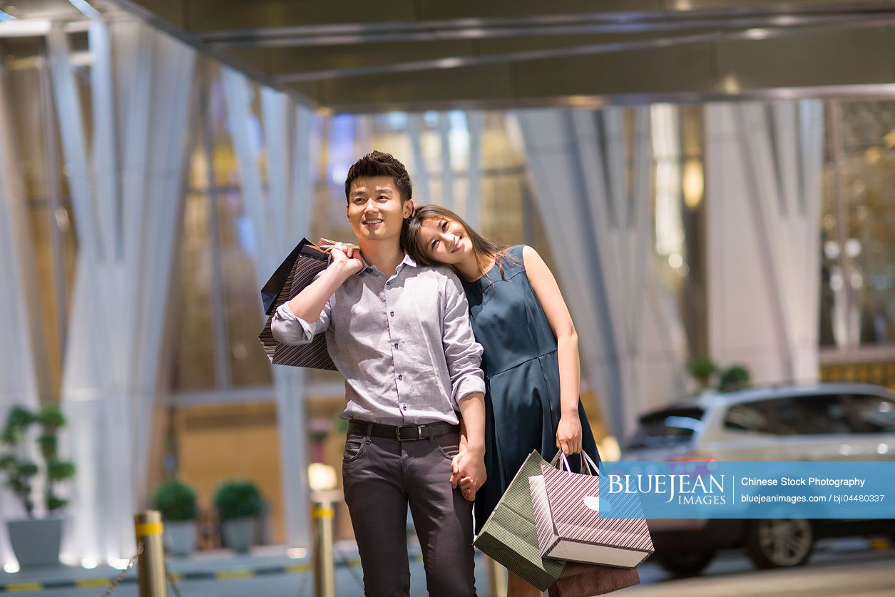 Happy young Chinese couple shopping