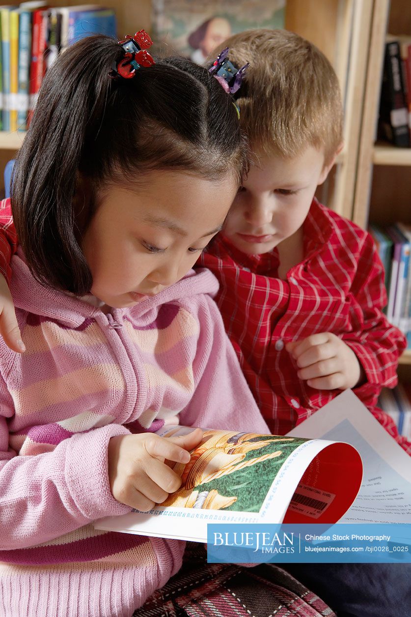 Children reading book together