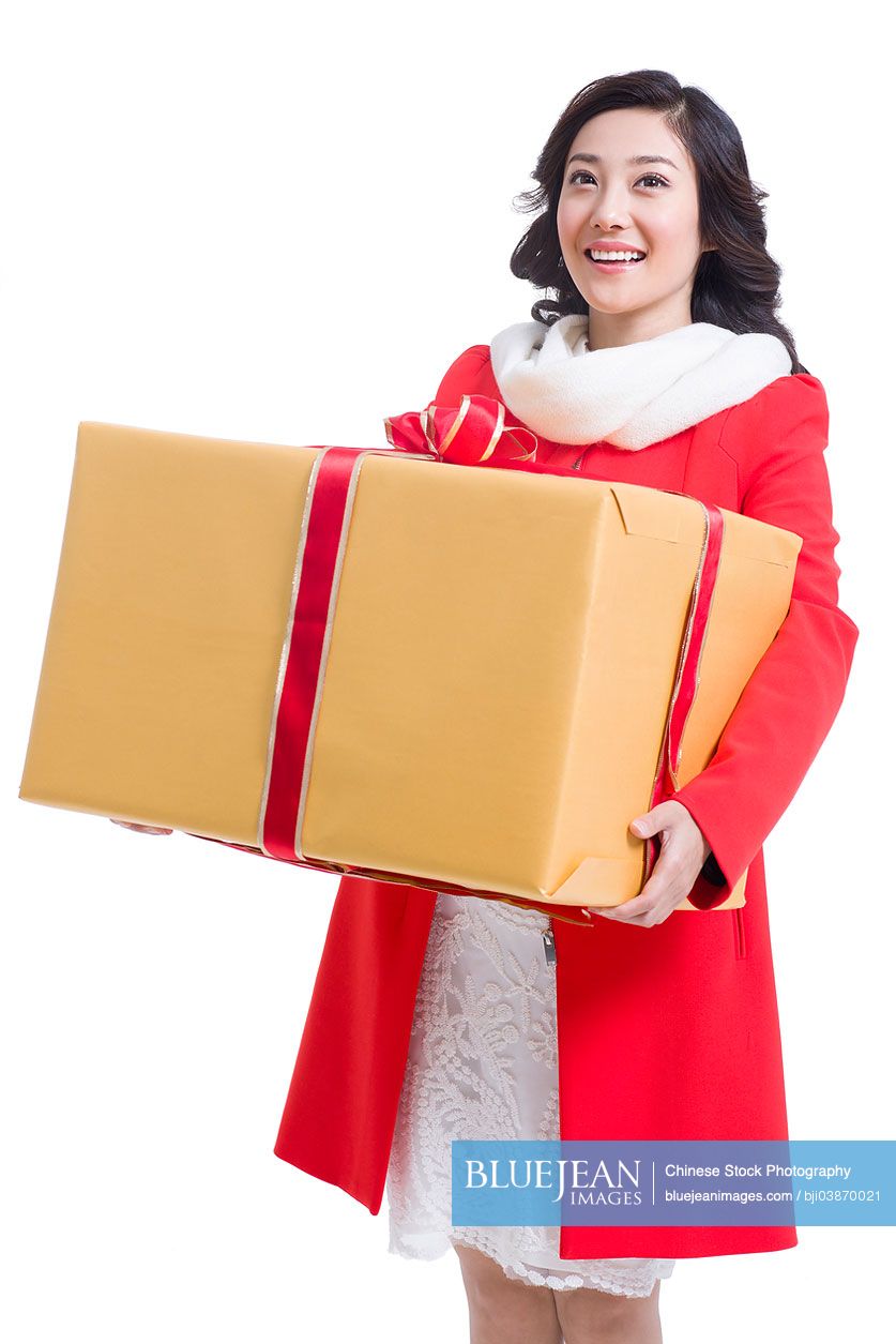 Happy young Chinese woman holding a large gift