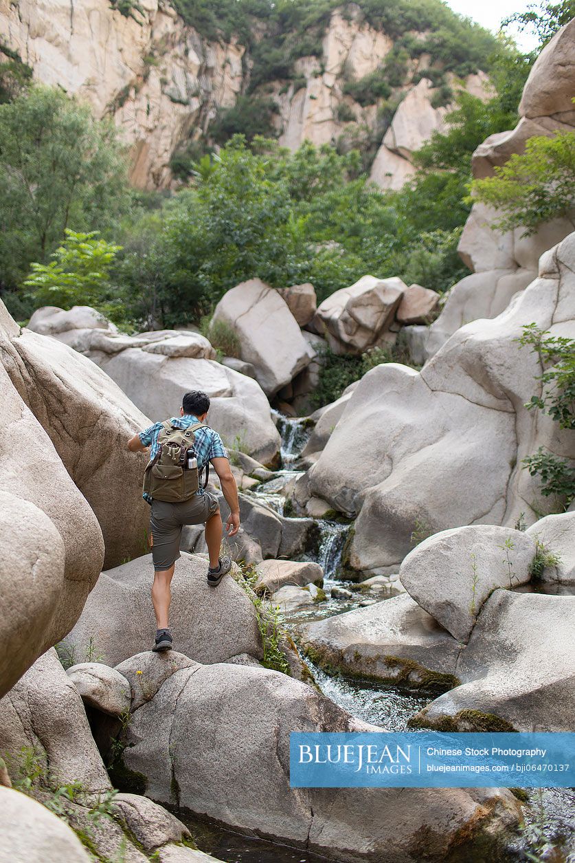 Young Chinese man hiking outdoors