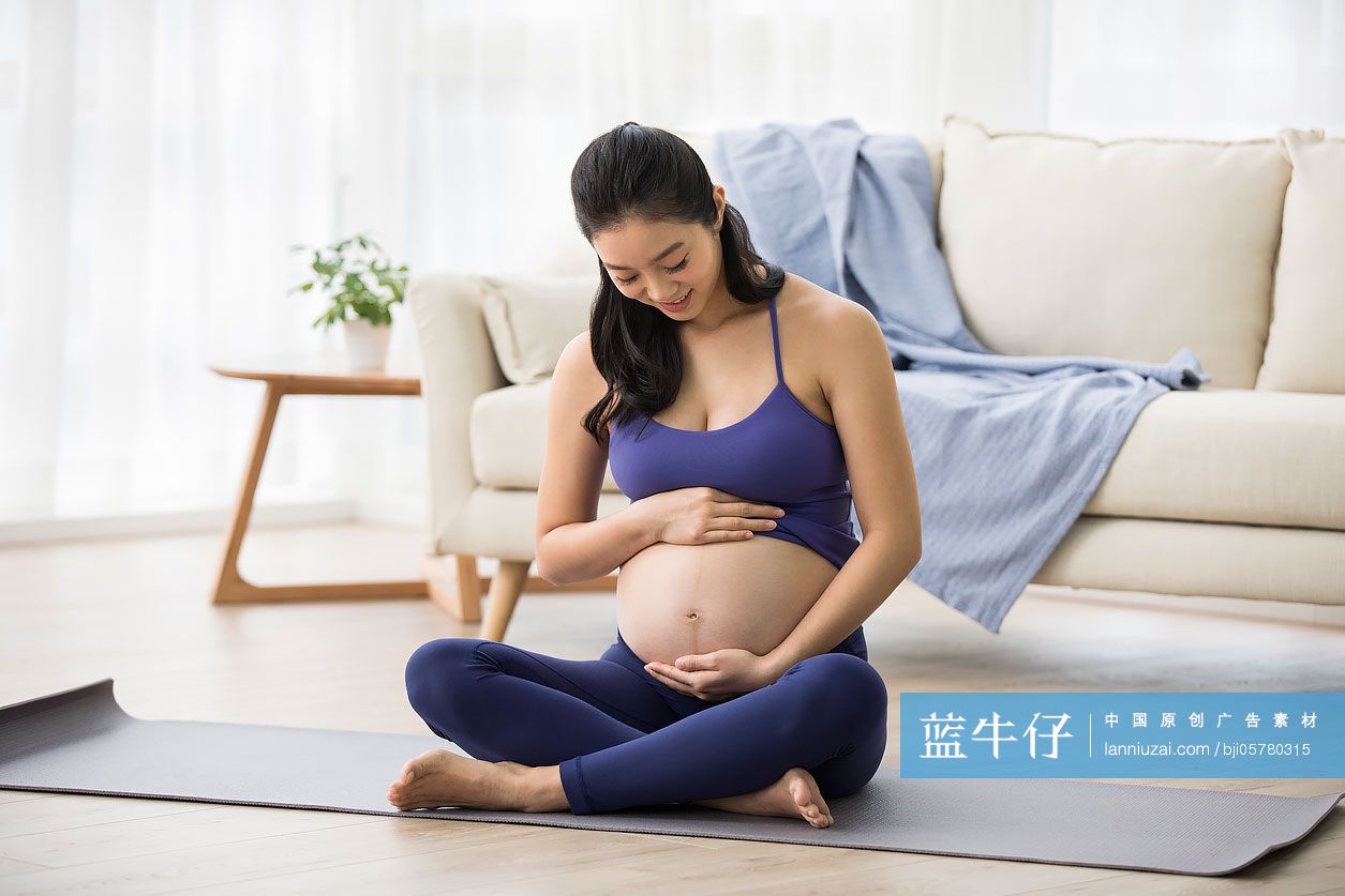 年轻孕妇手放在肚子上