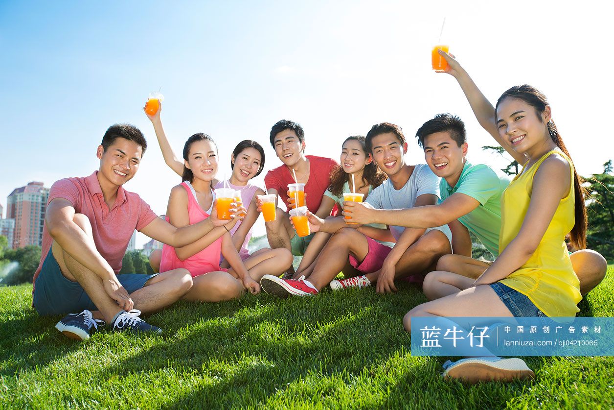 一群朋友坐在草地上喝饮料