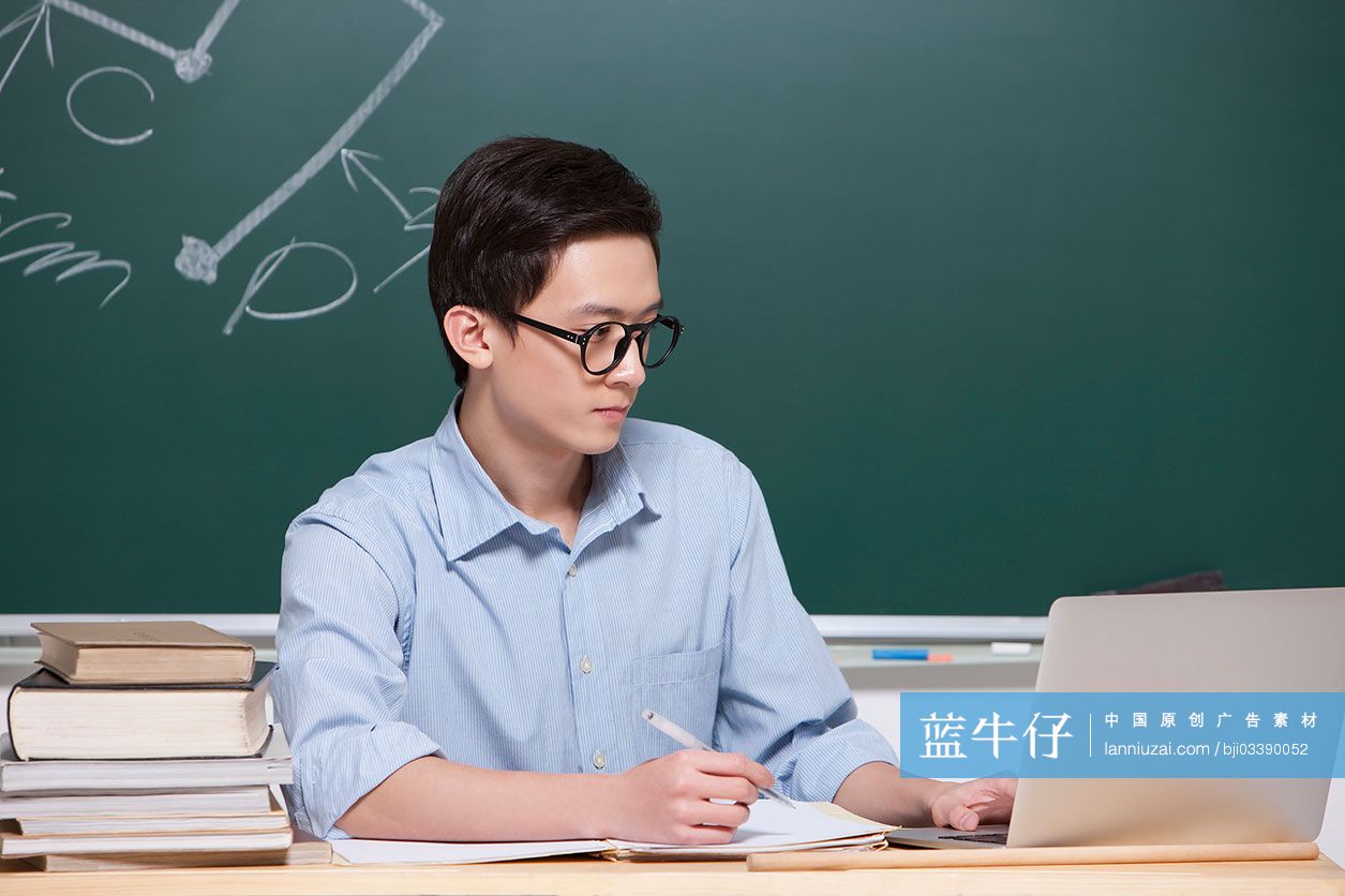 男老师在教室使用笔记本电脑