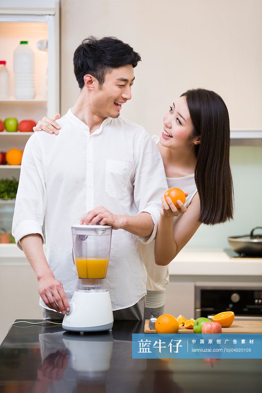 年轻夫妇在厨房使用榨汁机