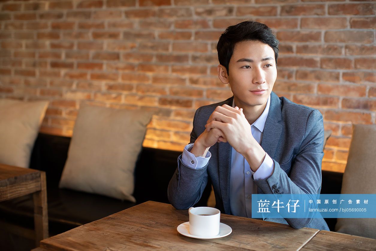 年轻商务男士在咖啡店喝咖啡