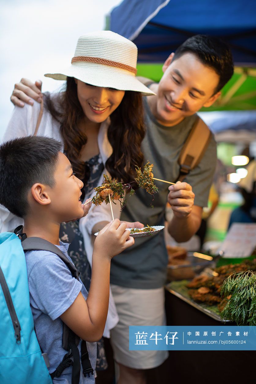 快乐的年轻家庭在街头品尝美食