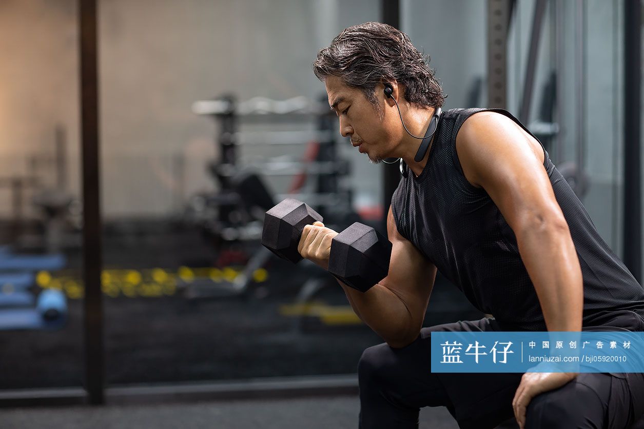 成熟男士在健身房举哑铃