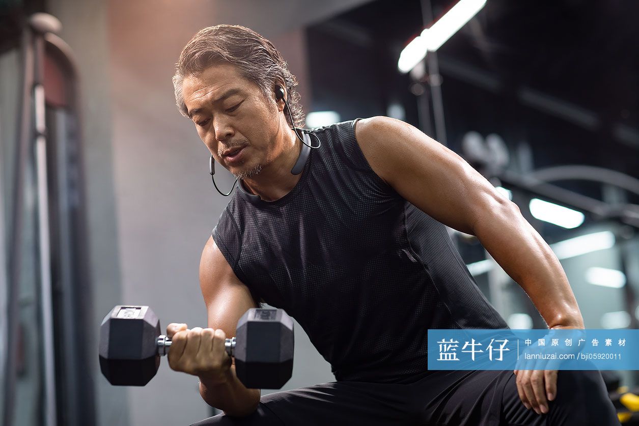 成熟男士在健身房举哑铃