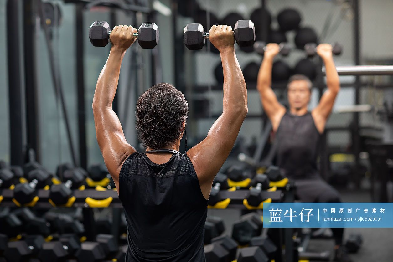 成熟男士在健身房举哑铃