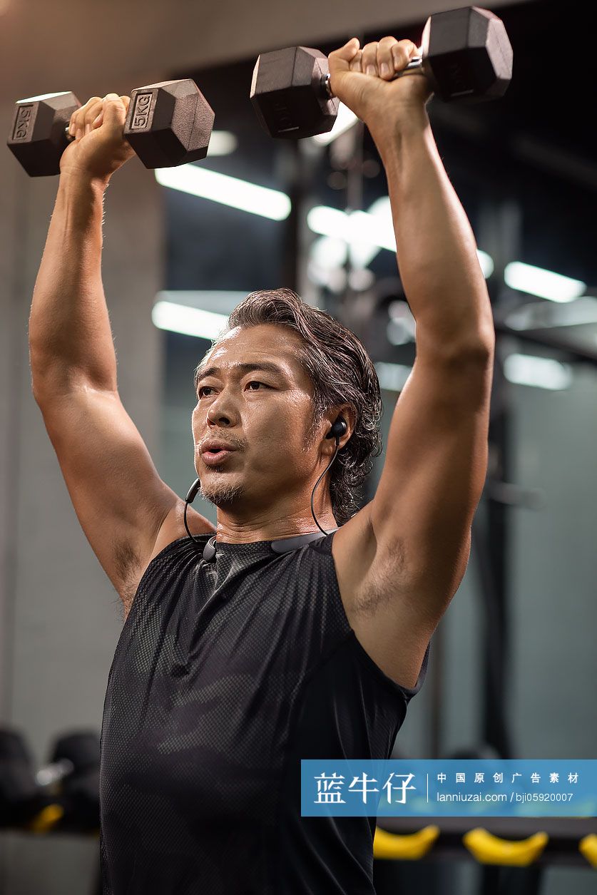成熟男士在健身房举哑铃