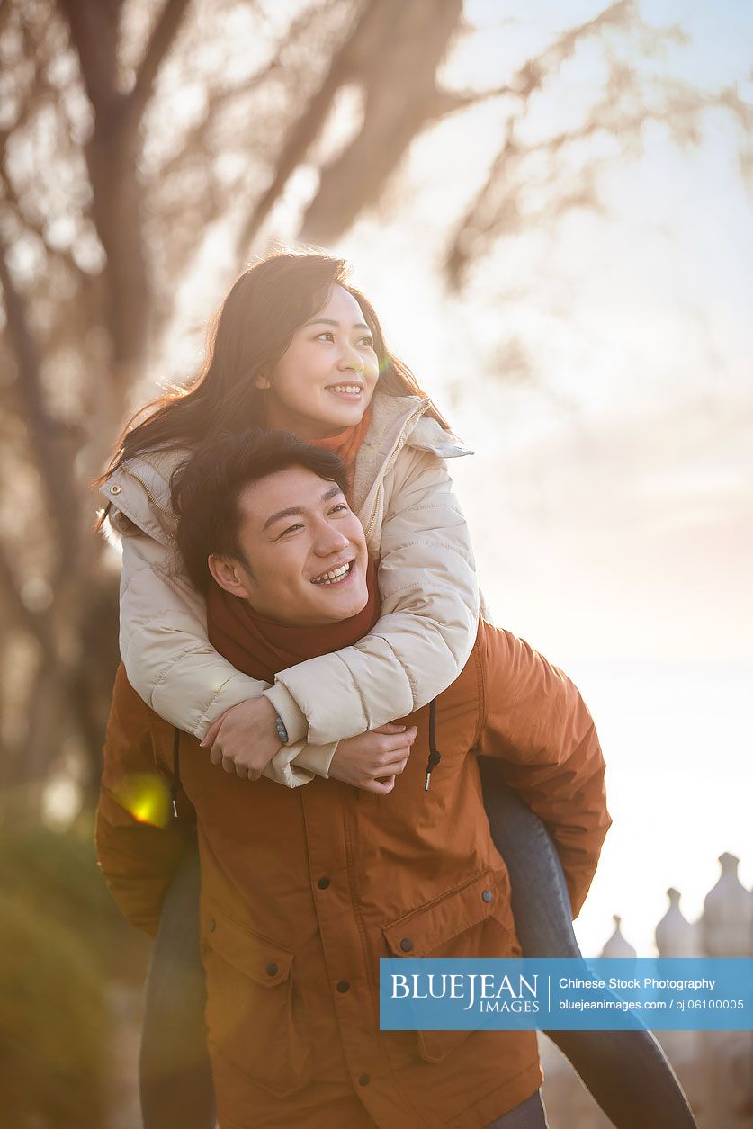 Happy young Chinese couple dating outdoors in winter
