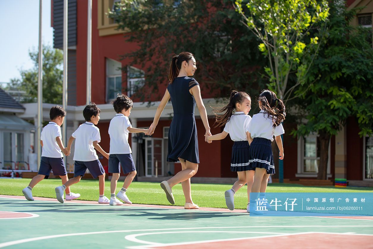 幼儿园老师和学生在操场上