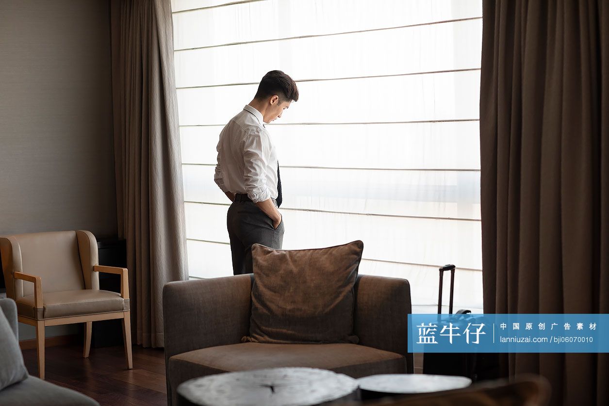 年轻商务男士站在窗前-蓝牛仔影像-中国原创广告影像素材