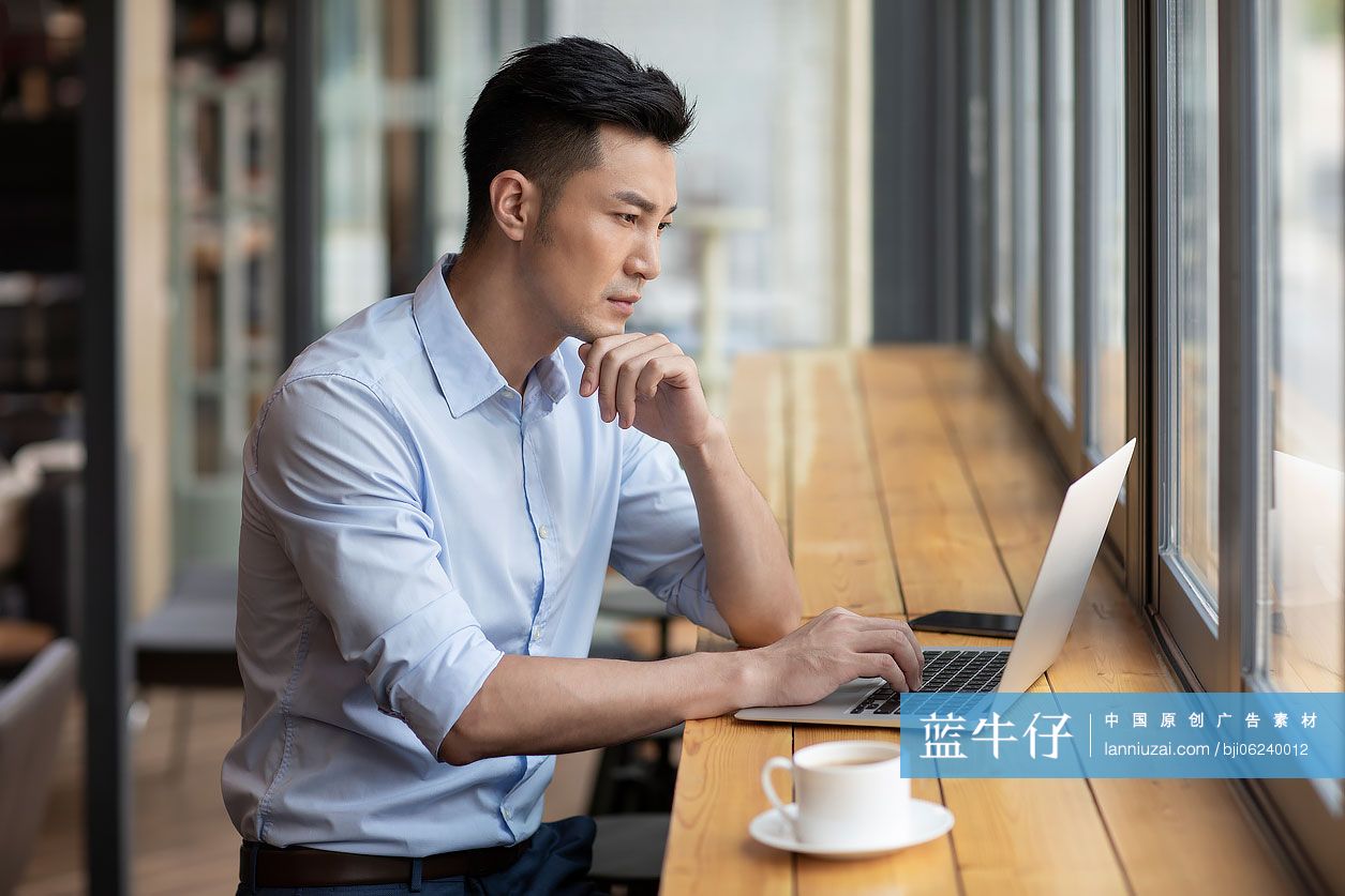 商务男子在咖啡馆使用笔记本电脑工作