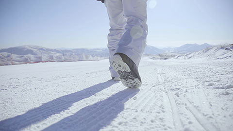 Young Chinese man walking with snowboard on the snow,4K