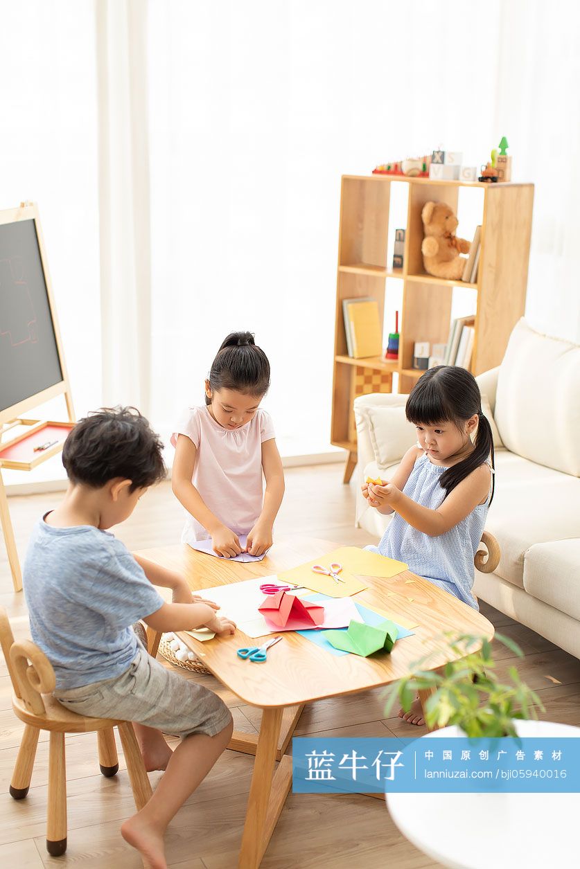 三个小朋友在客厅做折纸手工