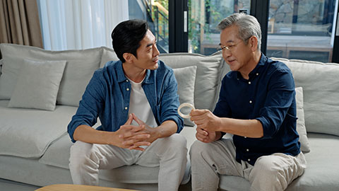 中年男子和父亲在家里鉴定古董