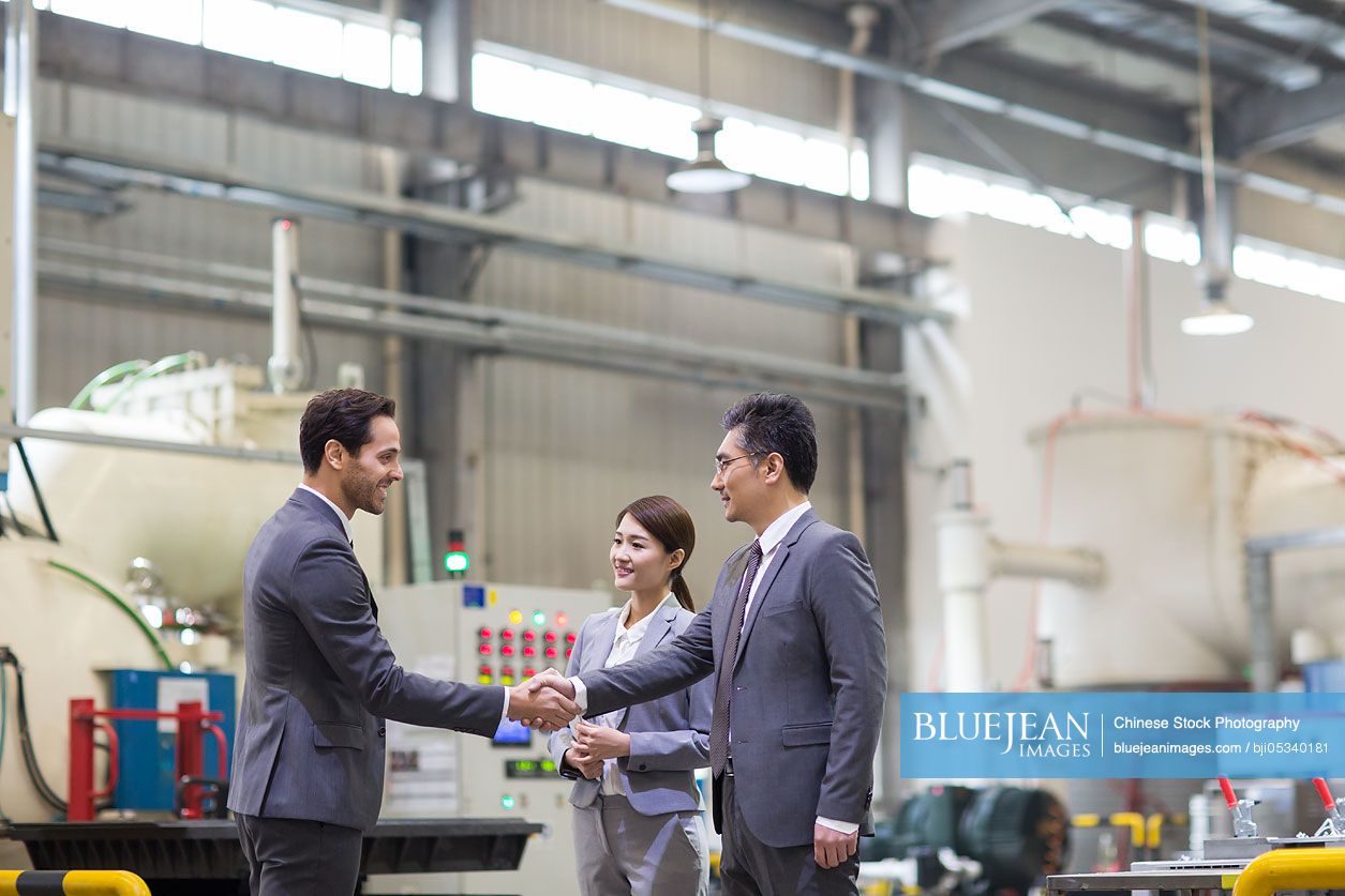 Business people shaking hands in the factory