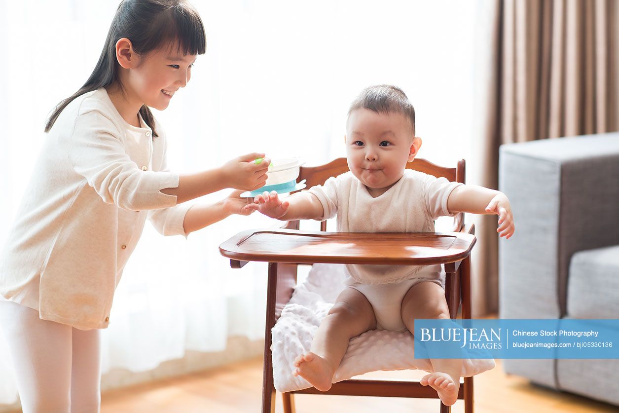 Little Chinese girl feeding baby