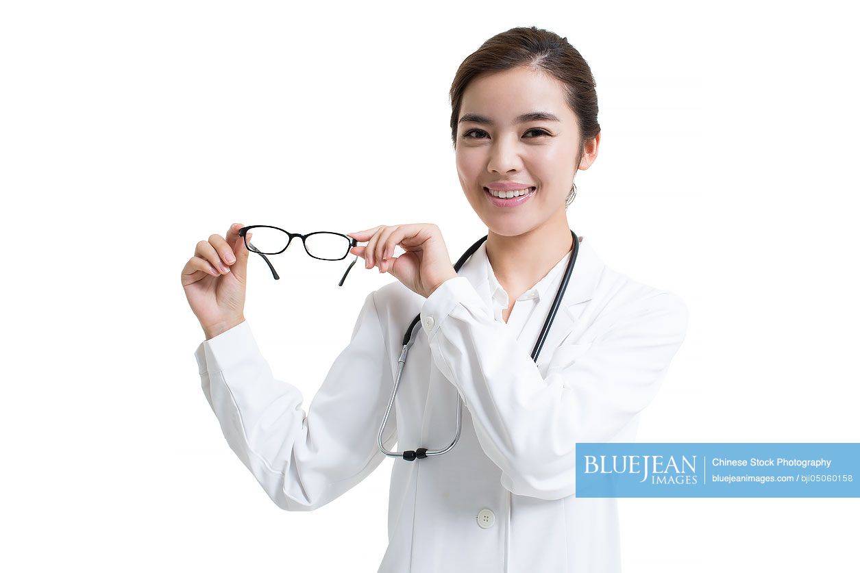 Young female Chinese doctor holding glasses