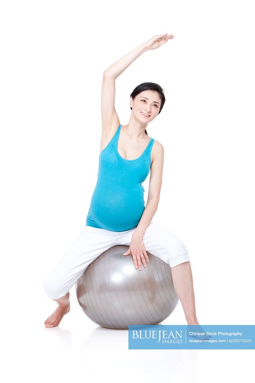 Chinese pregnant woman sitting on fitness ball