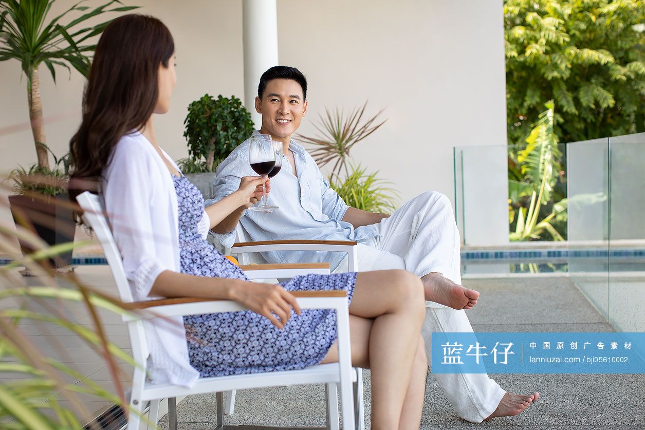 年轻夫妇在露台喝红酒