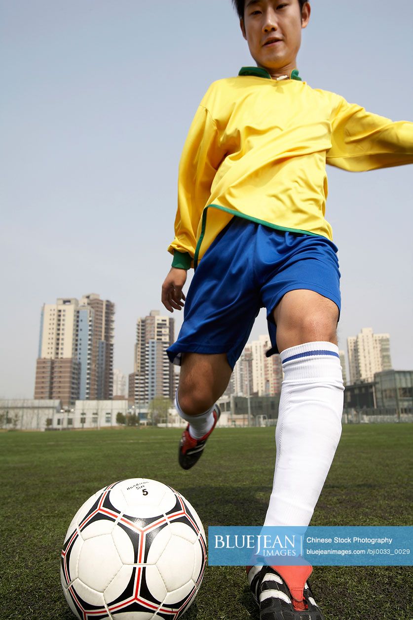 Chinese Man Playing Soccer-High-res stock photo for download