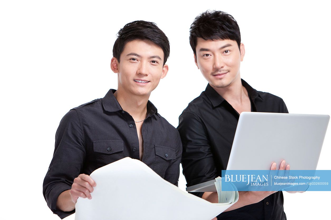 Chinese designers with laptop and blueprint