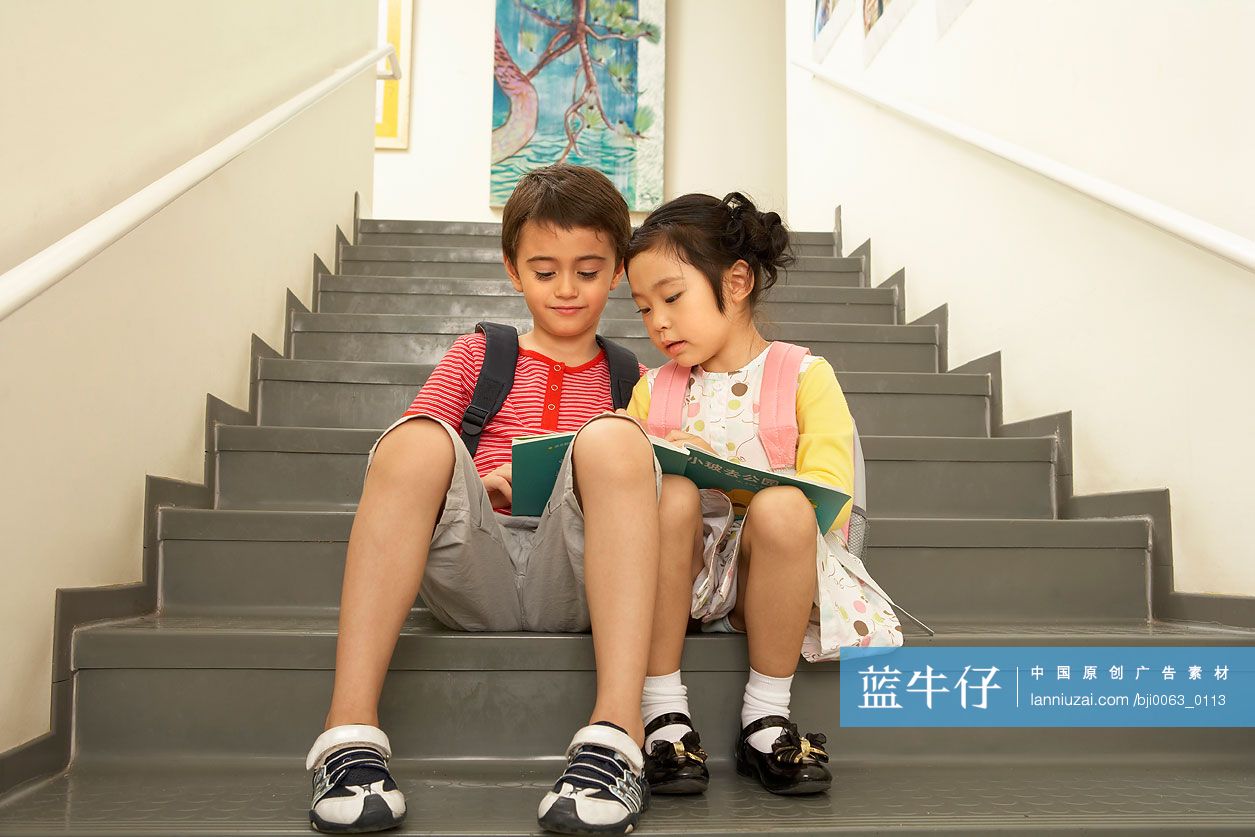 小男孩和小女孩坐在楼梯上看书