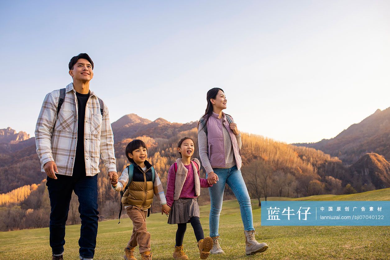 快乐的年轻家庭在草地上玩