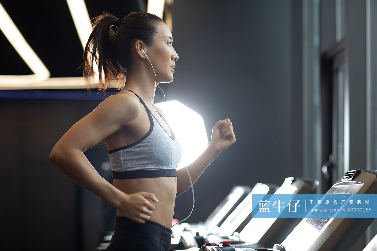 年轻女士在健身房跑步