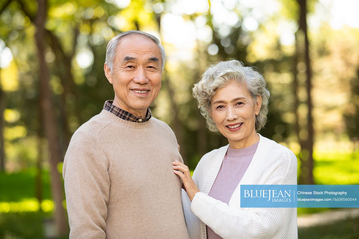 Cheerful senior Chinese couple dating in the park
