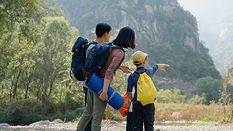 Happy young Chinese family hiking outdoors