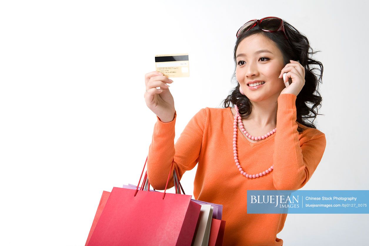 Chinese young woman with credit card and mobile phone