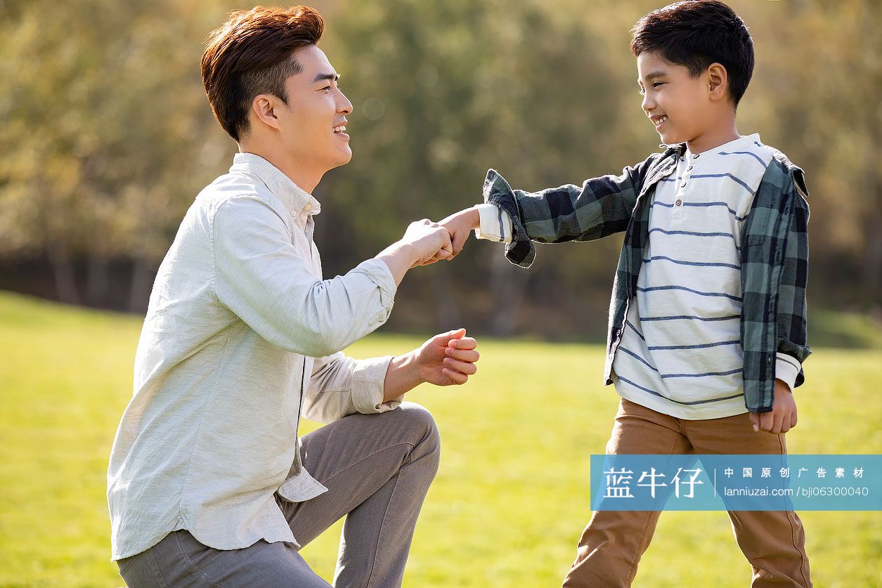 快乐的的父子俩在草地上玩耍